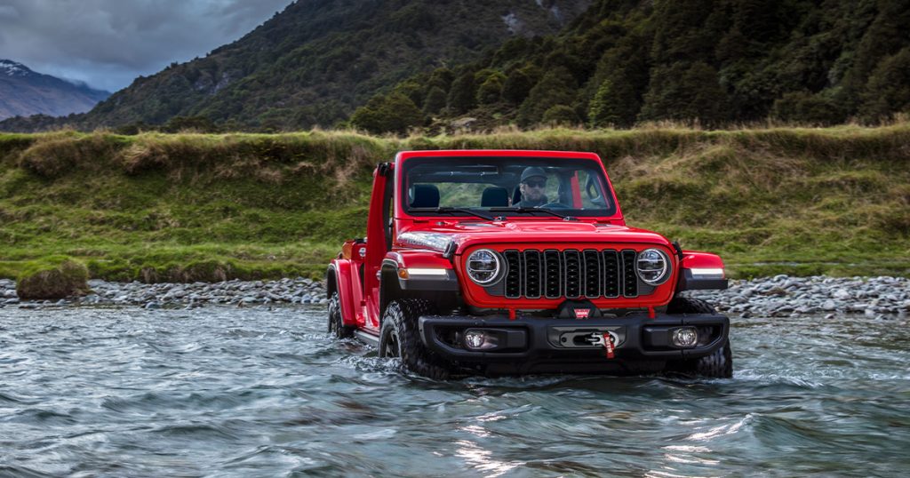 A Jeep Wrangler driving through high water.