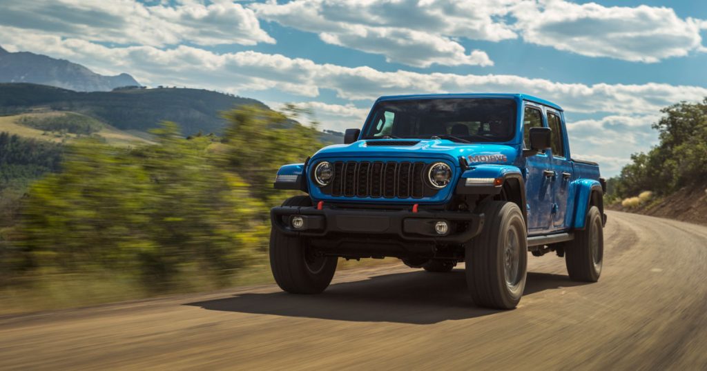 Hydro Blue Pearl 2025 Jeep Gladiator driving through mountains.
