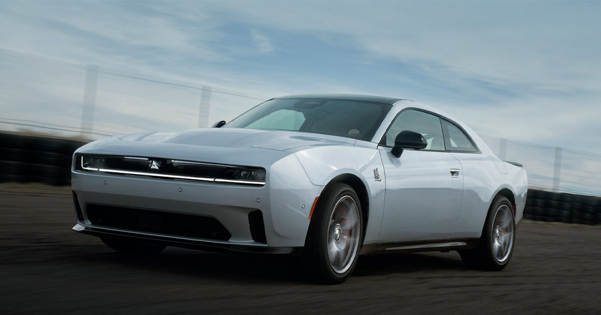 A Dodge Charger Daytona driving fast on a road.