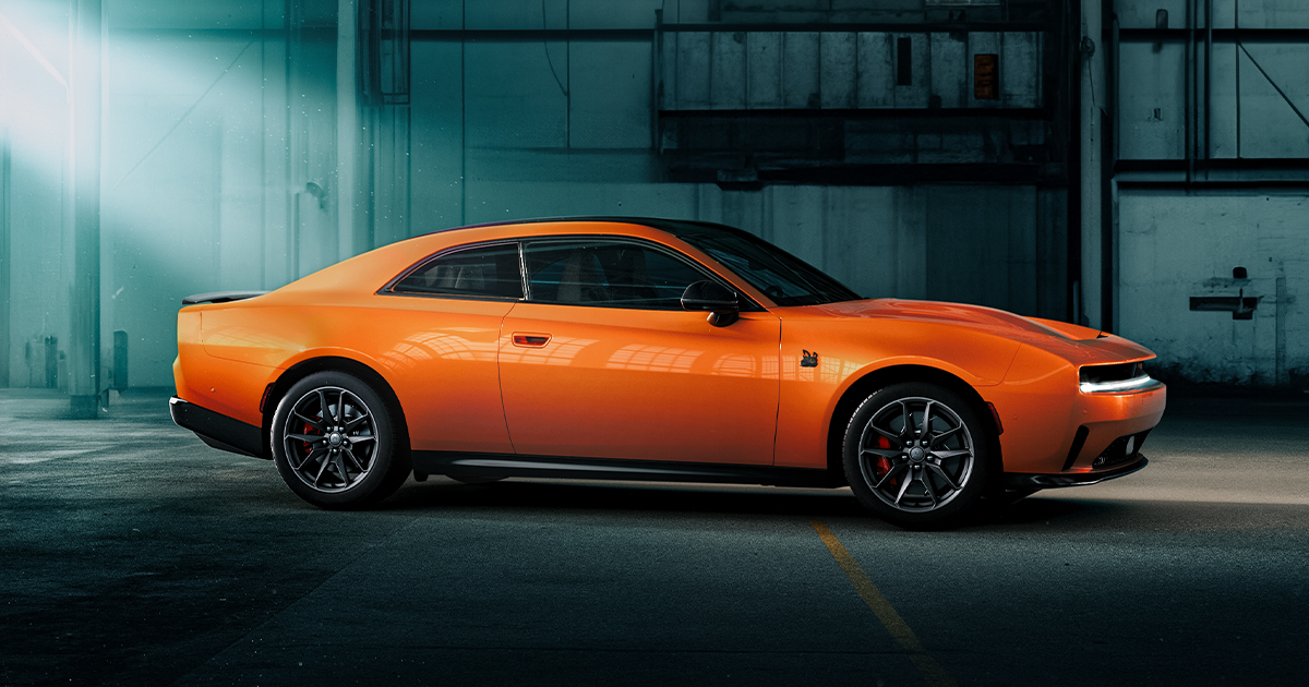 A Dodge Charger EV parked indoors under dramatic lighting