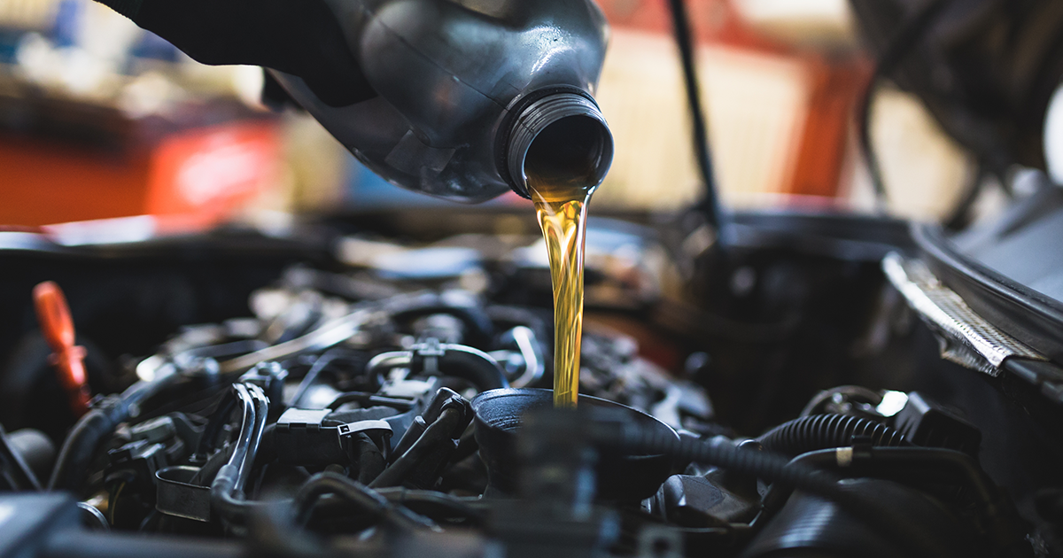 Close-up of a service technician performing an oil change service on a vehicle in the service center.